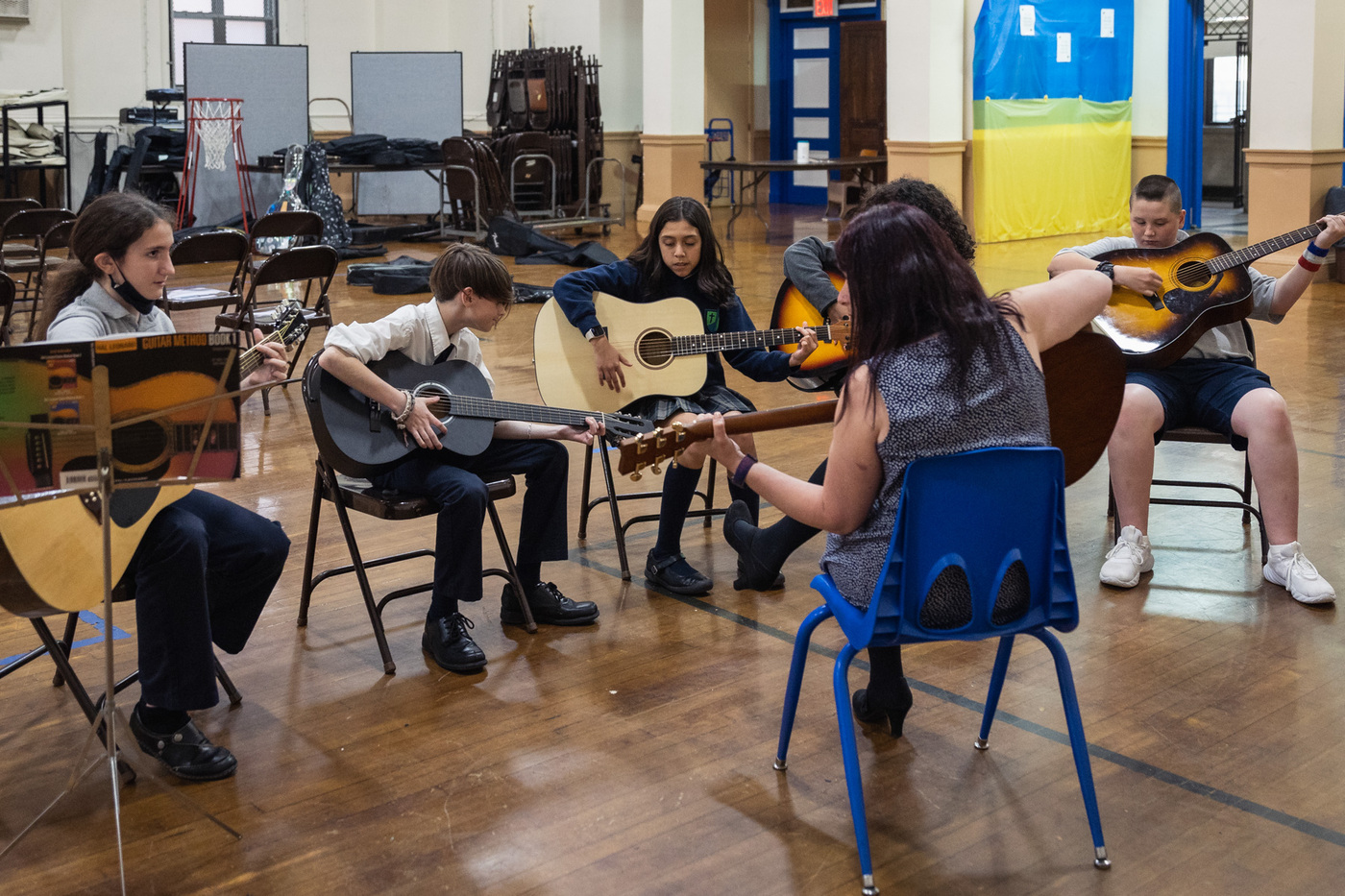 students and teacher playing guitar